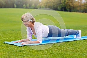 Mature woman practicing yoga in the park