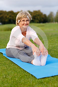 Mature woman practicing yoga in the park