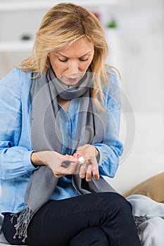 mature woman put plaster bandage on finger cut