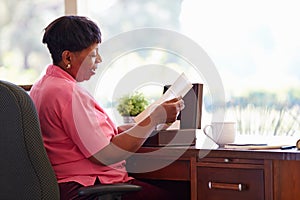 Mature Woman Putting Letter Into Keepsake Box photo
