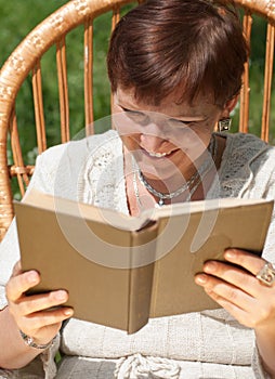 Mature woman reading book and laughing