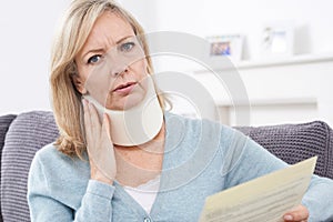 Mature Woman Reading Letter After Receiving Neck Injury