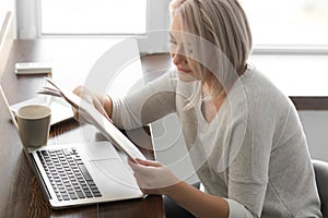 Mature woman reading newspaper in cafe