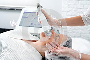 Mature woman receiving laser treatment in cosmetology clinic