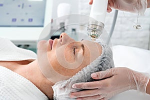 Mature woman receiving laser treatment in cosmetology clinic