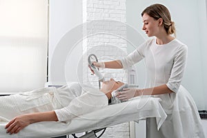 Mature woman receiving laser treatment in cosmetology clinic