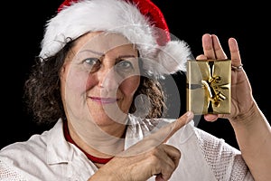 Mature Woman with Red Cap Pointing at Golden Gift
