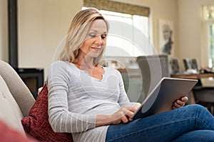 Mature woman relaxing with digital tablet