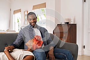 Mature woman relaxing on husband`s lap at home