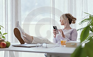 Mature woman relaxing and using her smartphone