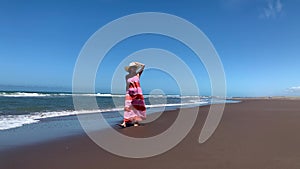 Mature woman relaxing during a walk at the beach. Summer concept, video 4k