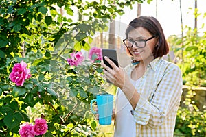Mature woman resting in backyard using smartphone for video call