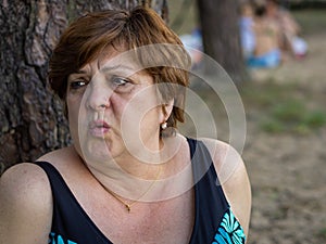 Mature woman resting on the beach by the lake