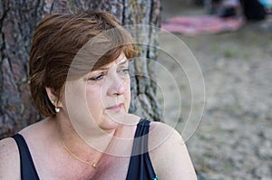 Mature woman resting on the beach by the lake