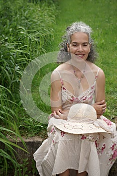 Mature woman in retro summer dress in a garden