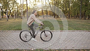 Mature woman riding bicycle at the sunset