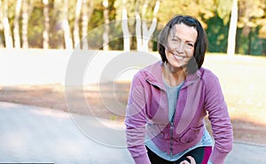 Mature woman runner taking a rest after running in the park