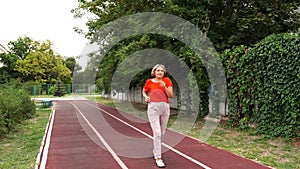 Mature woman running active in her 55s. Middle aged female jogging outdoor living healthy lifestyle