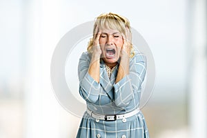 Mature woman screaming in despair.