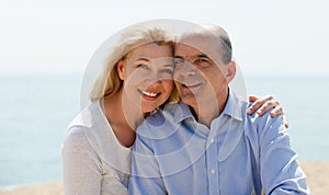 Mature woman and senior at sea beach on vacation smiling