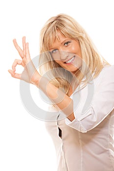 Mature woman showing ok sign hand gesture isolated