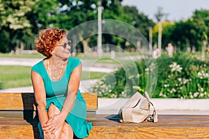 Mature woman sitting on the bench in the park