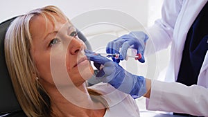 Mature Woman Sitting In Chair Being Give Botox Injection By Female Doctor photo