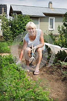 Mature woman sitting on a chair of his garden