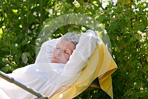 Mature woman sleeping on lounger