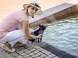 Mature woman with small dog walking in the Park