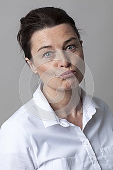 Mature woman with smart white shirt pouting for doubt