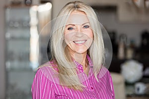 Mature woman smiling at the camera. She at home.