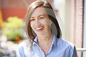 Mature Woman Smiling Outside On A Balcony