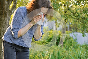 Mature woman sneezing in handkerchief, allergy to pollen, colds
