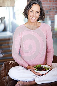 Mature woman, sofa and smile with salad or vegetables for diet, nutrition and health at home. Female person, couch and