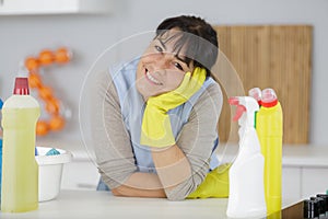 mature woman sourrounded by cleaning products