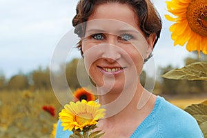 Mature woman standing in a sunflower field photo