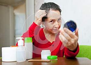 Mature woman stares on grizzled hair