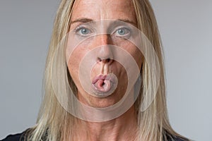 Mature woman sticking out her tongue at camera