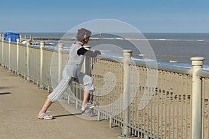 Mature woman streching by the beach