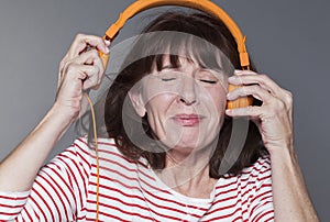 Mature woman suffering from listening to loud music on headphone