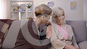 Mature woman supporting and comforting her elderly friend, health problems, loss