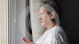 Mature woman takes capsules of cod-liver oil drinking water