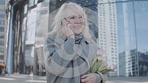 A mature woman talking by phone in the city