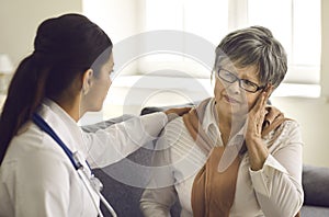 Mature woman telling doctor about her headaches during health checkup at hospital