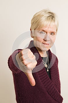 Mature woman with thumb down