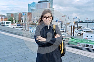 Mature woman tourist in Hamburg, posing in the river port