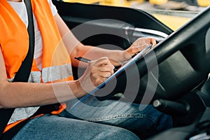 Mature woman truck driver steering wheel inside lorry cabin. Happy middle age female trucker portrait