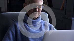Mature woman use laptop at home in living room. Akspb Focus from keyboard touchpad to old female