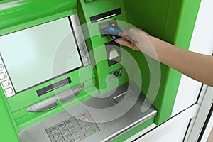 Mature woman using cash machine for  withdrawal, closeup